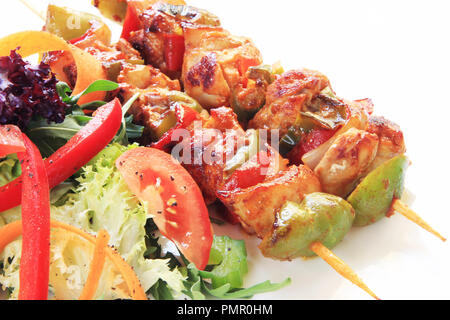 Fleisch und Gemüse vom Grill auf Feuer isoliert auf weißem Stockfoto