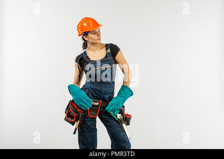 Bau- und home improvement Jobs Konzept mit einem kaukasischen brunette reife Frau tragen Helm oder harten Hut, Gürtel und sonstige Sicherheit equi Stockfoto