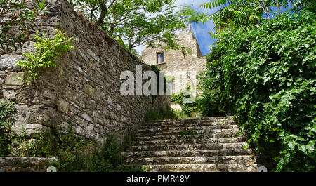 Steinerne Treppe neben einer alten Steinmauer zu einem Haus mit Steinfassade Stockfoto