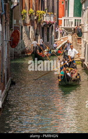 Gondeln Touristen in einem schmalen Kanal in Venedig, Italien. Stockfoto