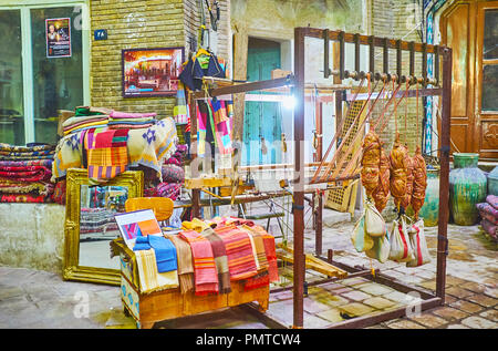 KASHAN, IRAN - Oktober 22, 2017: Traditionelle Webstuhl mit Beispielen von natürlichen Stoffen vor textilgeschäft in Aminoddole Karawanserei des Gr Stockfoto