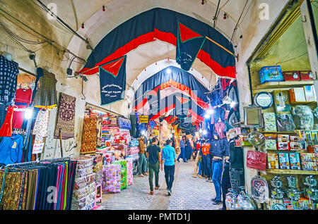 KASHAN, IRAN - Oktober 22, 2017: Besetzt Gasse der Altstadt Grand Bazaar, mit Flaggen von Muharram Festival dekoriert, einheimische Spaziergang entlang der Geschäfte von househo Stockfoto