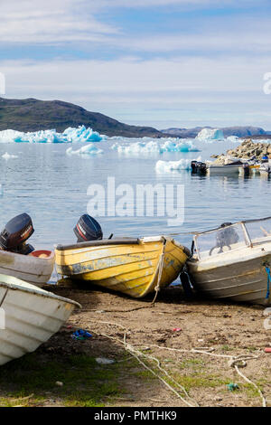 Kleine Inuit Fischerboote im Hafen mit Eisbergen Qajaq offshore im Sommer. Narsaq, Kujalleq, Südgrönland Stockfoto