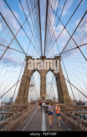 NEW YORK - 26. AUGUST 2017: Touristen und Einheimische Kampf um Platz auf der überfüllten Fußgängerzone über die Brooklyn Bridge bei Sonnenuntergang. Stockfoto