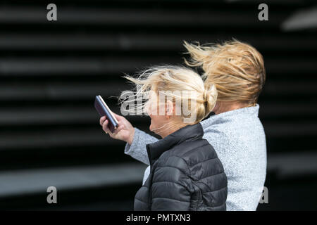 Dundee, Schottland. UK Wetter 19/09/2018. Sturmwind hit Norden Schottlands. Besucher der Stadt haben strenge Winde mit Fußgängern auf der Strandpromenade ausgeblasen wird zu ertragen. Sturm Ali, Schlag, tempest, Flyaway Haar, verwirrte Tresses, Bad Hair Day. Kredit; MediaWorldImages/AlamyLiveNews. Stockfoto