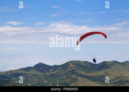 Berg Gleitschirmfliegen, Fallschirmspringen fliegen über die Berge. Fallschirm Extremsport. Stockfoto