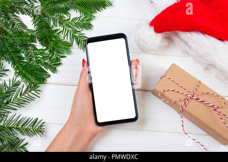 Weibliche Käufer macht, um auf den Bildschirm des Smartphones mit kopieren. Weihnachten online einkaufen. Frau kauft Geschenke für Weihnachten. Winterurlaub Vertrieb. Stockfoto