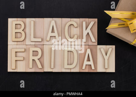 Schwarzer Freitag - Text in Holz- Buchstaben auf der Tafel mit Geschenk. Kopieren Sie Platz. Stockfoto