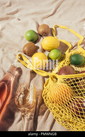 Blick von oben auf Glas, Flasche mit Sommer trinken und Gelb string Beutel mit frischen Reifen tropischen Früchten Stockfoto