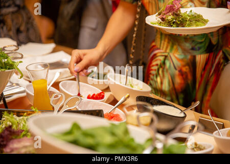 Eine Gruppe von Touristen im Freien speisen. Eine Frau ist mit Essen. Buffet. Empfang Stockfoto