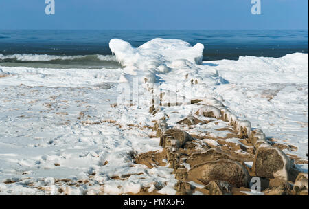 Wellenbrecher im Eis, das Eis auf dem Wellenbrecher im Meer Stockfoto