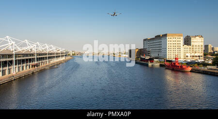 London, England, Großbritannien - 2 September, 2018: Eine kleine Passagier Flugzeug fliegen tief über Royal Victoria Dock, durch das Ausstellungszentrum ExCeL flankiert und Mühle Stockfoto