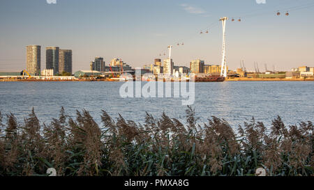 London, England, Großbritannien - 2 September, 2018: die Abendsonne beleuchtet die Emirates Air Line Seilbahn die Themse, Kreuzung mit modernen Apartment buil Stockfoto