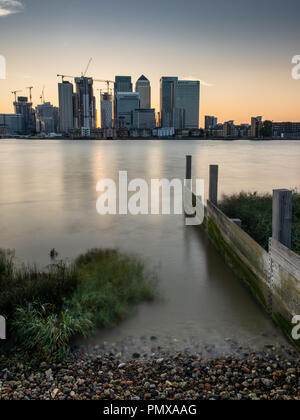 London, England, Großbritannien - 2 September, 2018: Die Sonne hinter einem Cluster von Wolkenkratzern in den Londoner Docklands Canary Wharf Nachbarschaft während der Fluss Stockfoto