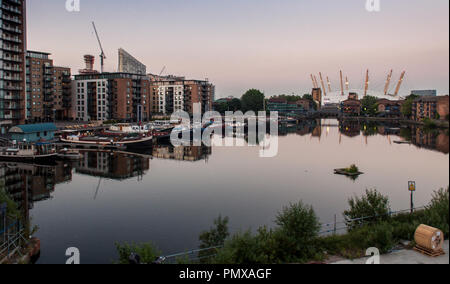 London, England, UK - 26. Juni 2010: Die O2 Millennium Dome ist in den Gewässern von Blackwall Basin's London Docklands bei Sonnenuntergang wider. Stockfoto