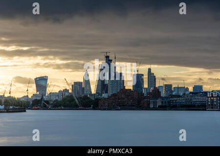 London, England, Großbritannien - 14 September, 2018: Die Sonne hinter der Silhouette der Stadt London Business District, mit Wolkenkratzern und Bau c Stockfoto