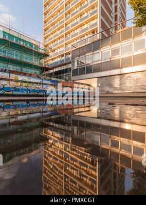 London, England, Großbritannien - 24 August 2010: Apartment Gebäude in eine Pfütze auf alten Straße in East London wider. Stockfoto