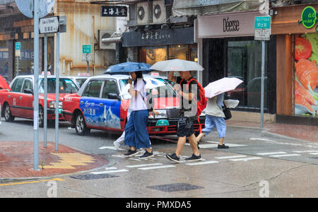 Hongkong - Juli 02, 2018: Die Menschen der Straße Kreuzung in Regen Stockfoto