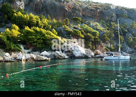Segelboote günstig an der felsigen Küste von Kroatien. Abend Bucht auf der Insel Hvar. Im Meer entspannen. Schiffe bei Sonnenuntergang. Urlaub auf einem Segelboot Stockfoto