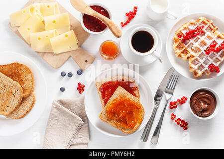 Frühstück mit Waffeln, Toast, Berry, Marmelade, Schokolade und Kaffee. Ansicht von oben Stockfoto