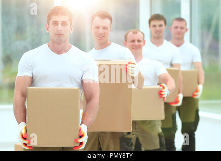 Team von Bauherren mit Boxen von Baustoffen Stockfoto