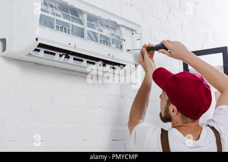 Nahaufnahme der professionellen Handwerker Filterwechsel für Klimagerät mit Schraubendreher Stockfoto