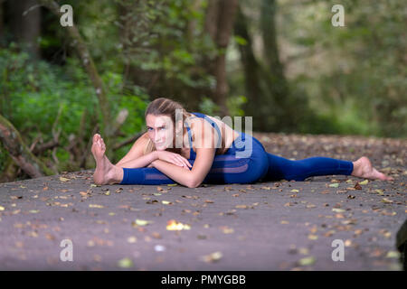 Junge Frau mit Yoga im Wald auf einen Holzsteg Stockfoto