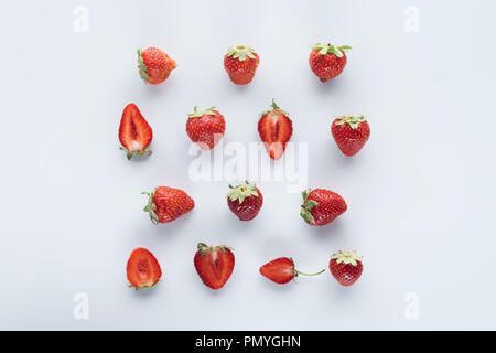 Ansicht von oben zu halbieren und die ganze Erdbeeren auf weiße Oberfläche Stockfoto
