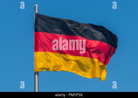 Deutsche Fahnen im Wind am berühmten Reichstag, Sitz des deutschen Parlaments (Deutscher Bundestag), an einem sonnigen Tag mit blauen Himmel, Centr Stockfoto