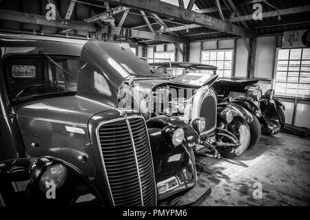 Detaillierte, arty, Schwarz und Weiß, Landschaft, Nahaufnahme der glänzenden, polierten Oldtimer klassische Autos geparkt, Seite an Seite, in eine offene Garage Platz. Stockfoto