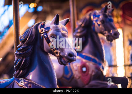 Brillante vintage Merry-go-round hölzerne Pferde vor dem Hintergrund des Kinder- Karussell in der Nacht. Stockfoto