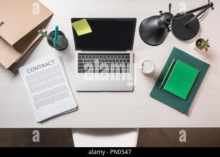 Ansicht von Notebook, Papier Tasse Kaffee-, Vertrags- und Schreibwaren auf Tisch Stockfoto