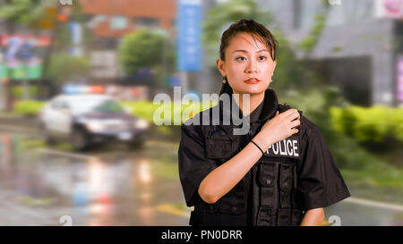 Asiatische amerikanische Polizistin am Tatort sprechen für CB-Funk Stockfoto