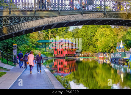 Schöne Aussicht auf den Regent's Canal in London, England, bei Sonnenuntergang im Sommer; Menschen zu Fuß entlang, Brücke oben Stockfoto