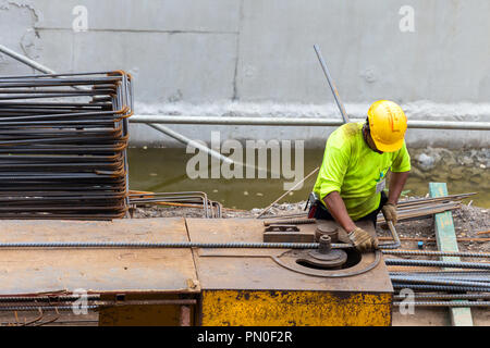 Asiatische Bauarbeiter mit Stahl Biegemaschine bender Armierungseisen für das Gießen Stiftung konkrete Säulen an Gebäude Baustelle. konstruieren Stockfoto