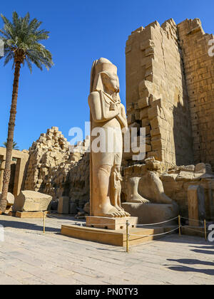 Eine Statue von Ramses II. mit dem kleineren Statue von seiner Tochter Verbogen'anta am Karnak Komplex, oder Tempel von Karnak, Luxor, Ägypten Stockfoto