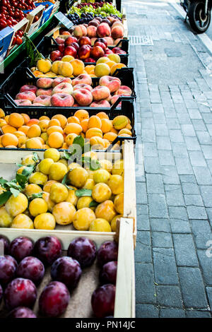 Straße Obstmarkt. Verschiedene Sorten frische reife Pflaumen, Pfirsiche und Weintrauben in Kisten aus Holz, entlang der Straße. Sommer Italien, Sorrento Stockfoto