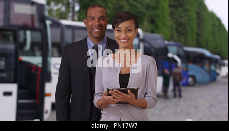 Zwei junge afrikanische Führer stolz in der Nähe einige Tour Busse posing Stockfoto