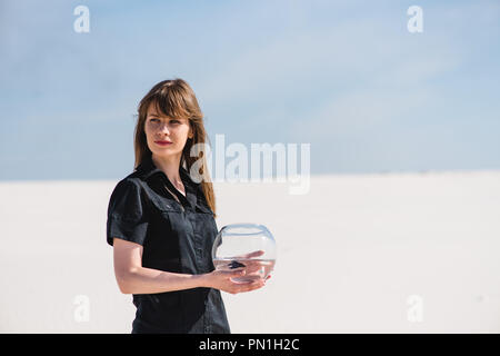 Frau mit Aquarium Fische in der Wüste Stockfoto