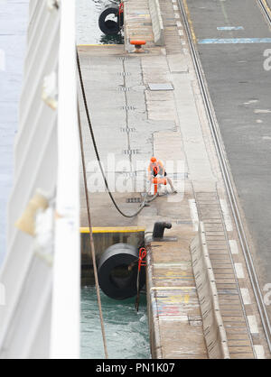 Eine Ladestation oder stevedore Spaziergänge neben einem gerade angekommen cargo Schiff in den Hafen von Barcelona. Stockfoto