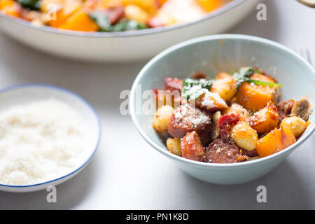 Gnocchi mit Chorizo, Butternut, Spinat, Pilze, sonnengetrocknete Tomaten und Parmesan Stockfoto