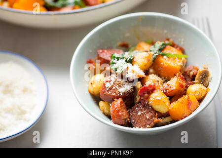 Gnocchi mit Chorizo, Butternut, Spinat, Pilze, sonnengetrocknete Tomaten und Parmesan Stockfoto