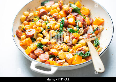 Gnocchi mit Chorizo, Butternut, Spinat, Pilze, sonnengetrocknete Tomaten und Parmesan Stockfoto