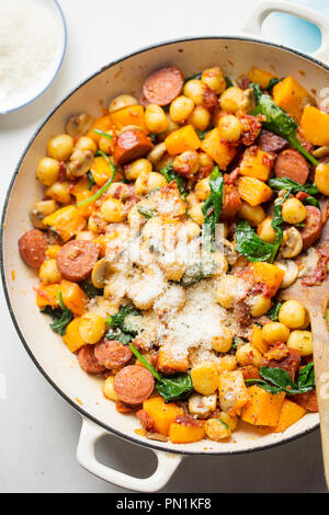 Gnocchi mit Chorizo, Butternut, Spinat, Pilze, sonnengetrocknete Tomaten und Parmesan Stockfoto