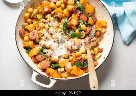 Gnocchi mit Chorizo, Butternut, Spinat, Pilze, sonnengetrocknete Tomaten und Parmesan Stockfoto