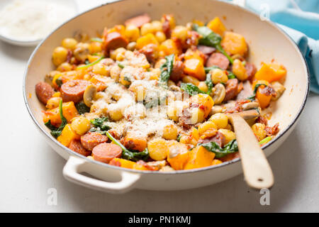 Gnocchi mit Chorizo, Butternut, Spinat, Pilze, sonnengetrocknete Tomaten und Parmesan Stockfoto