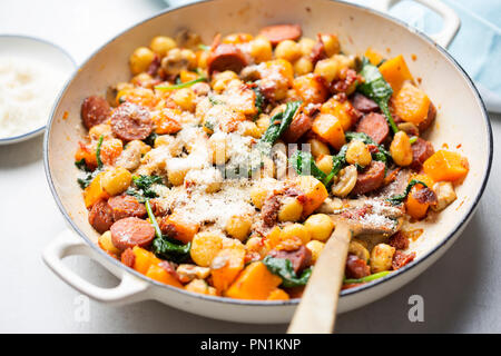 Gnocchi mit Chorizo, Butternut, Spinat, Pilze, sonnengetrocknete Tomaten und Parmesan Stockfoto