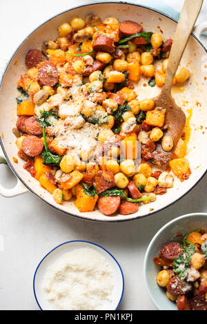 Gnocchi mit Chorizo, Butternut, Spinat, Pilze, sonnengetrocknete Tomaten und Parmesan Stockfoto