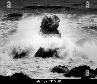 Ocean waves Crash in einem seltsam geformten Felsen. Stockfoto