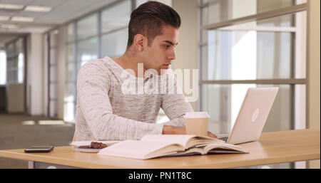 Tausendjährige Latino Studenten im Wohnheim Arbeiten am Laptop Stockfoto
